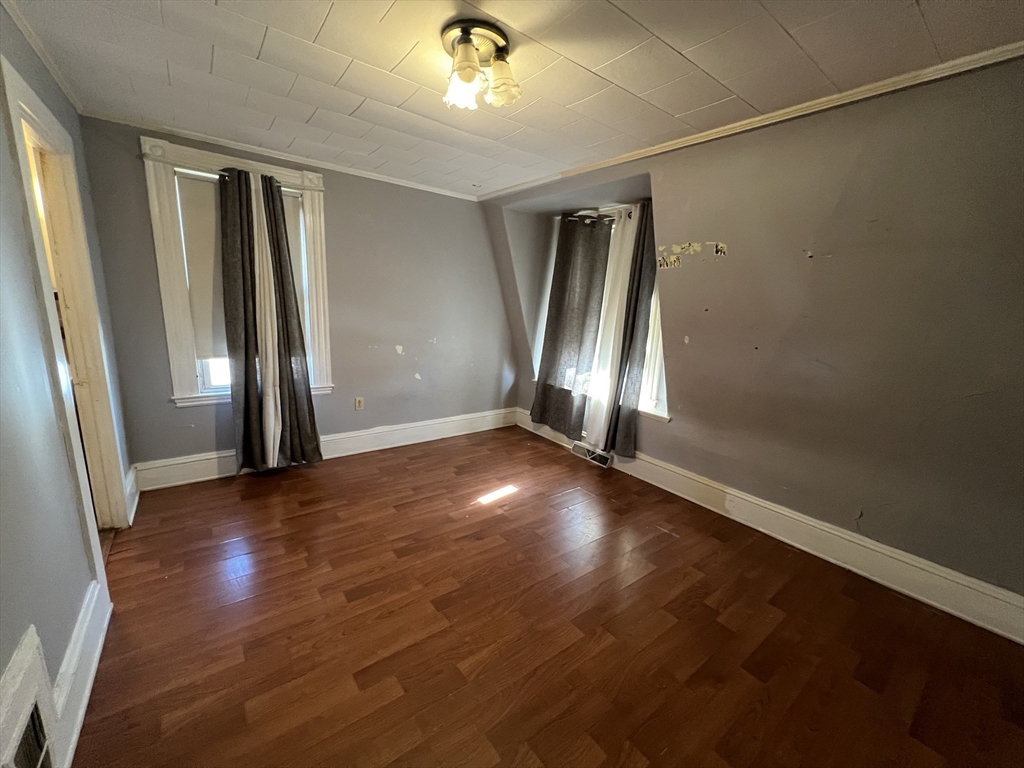 34 Chestnut Street, Unit 3 Wakefield, MA 01880 - Photo 3 of 7 an empty room with wooden floor and windows