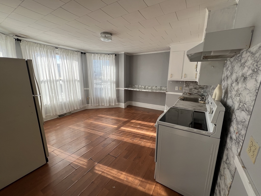 34 Chestnut Street, Unit 3 Wakefield, MA 01880 - Photo 6 of 7 a view of a kitchen with fridge and wooden floor