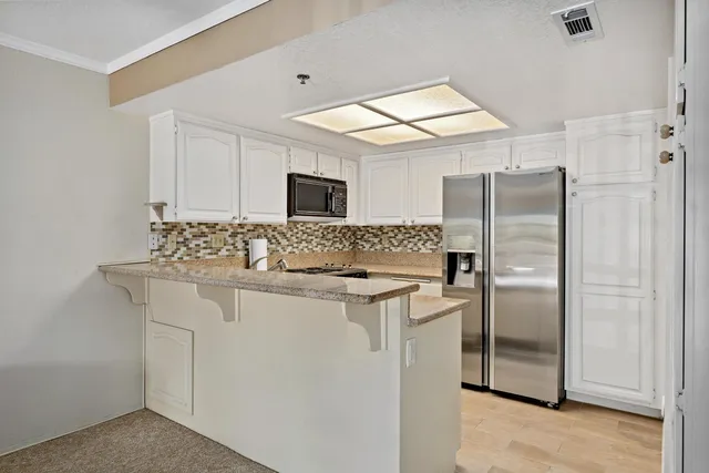 a kitchen with stainless steel appliances a refrigerator sink and microwave