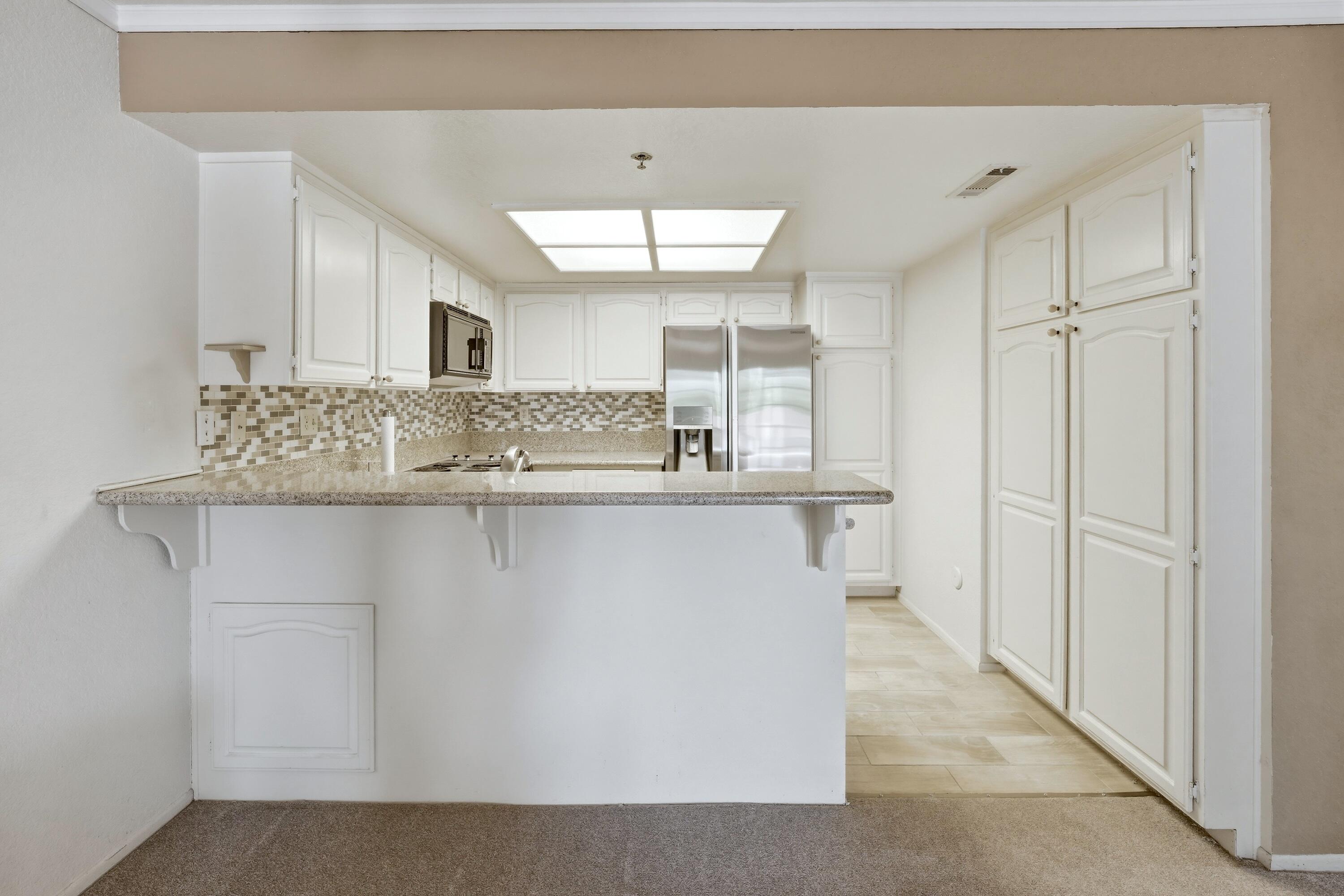 500 East Amado Road, Unit 511 Palm Springs, CA 92262 - Photo 15 of 28 a bathroom with a granite countertop sink a mirror and a bathtub