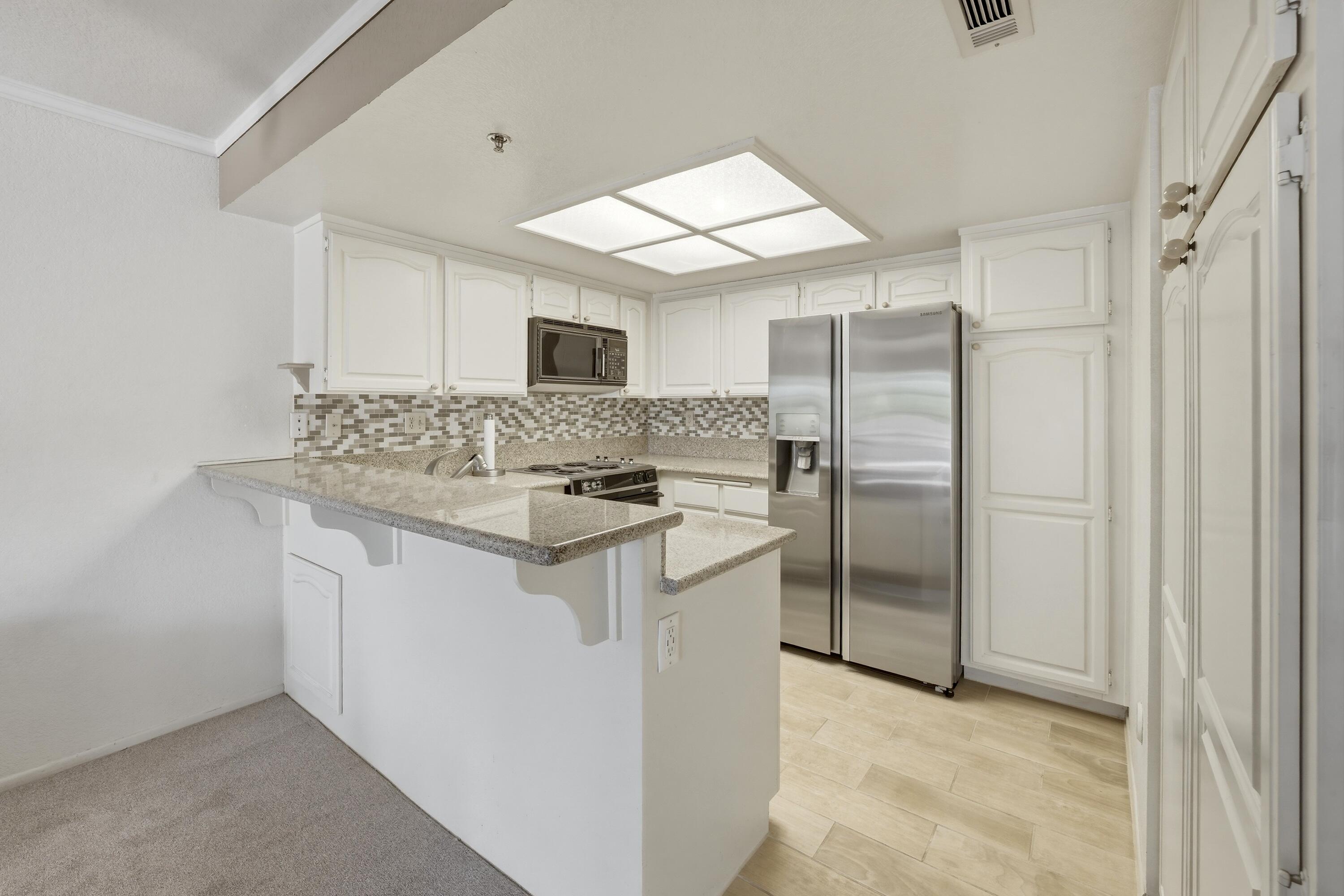 500 East Amado Road, Unit 511 Palm Springs, CA 92262 - Photo 16 of 28 a kitchen with stainless steel appliances granite countertop a sink stove and refrigerator