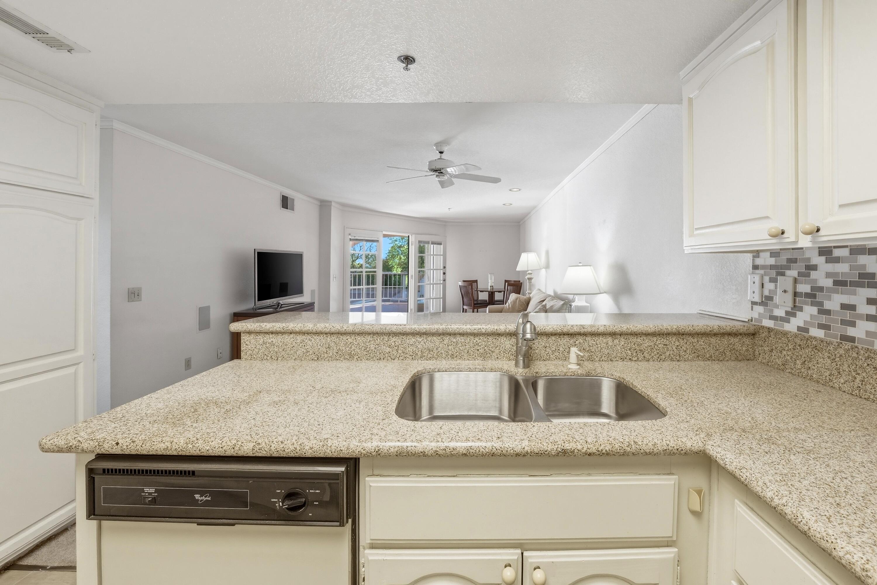 500 East Amado Road, Unit 511 Palm Springs, CA 92262 - Photo 18 of 28 a kitchen with granite countertop a sink and a stove top oven with wooden floor