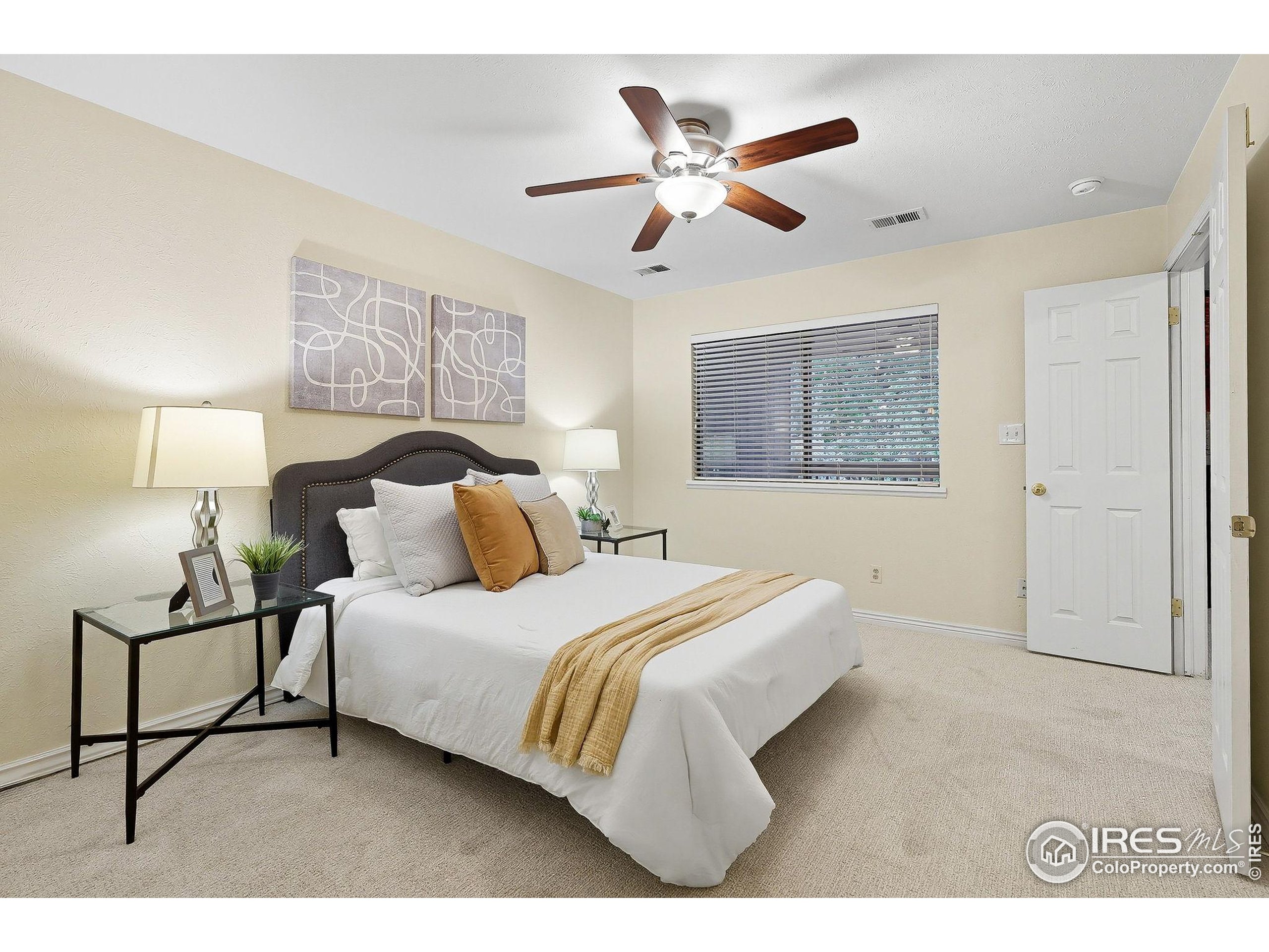1303 Alpine Avenue, Unit 24 Boulder, CO 80304 - Photo 19 of 46 a bedroom with a bed and lamp with window