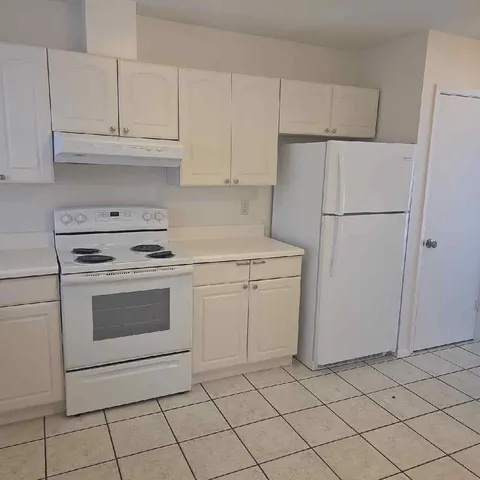 a kitchen with white cabinets and white appliances