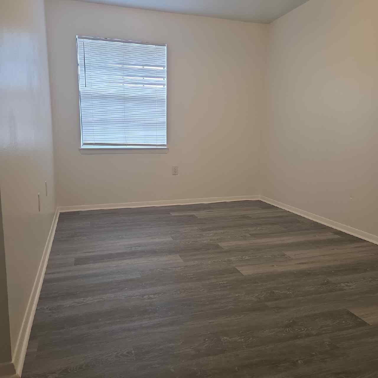 90 6th Avenue, Unit 4 Shalimar, FL 32579 - Photo 7 of 10 a view of an empty room with wooden floor and a window
