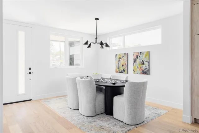 a dining room with wooden floor a chandelier a wooden table and chairs