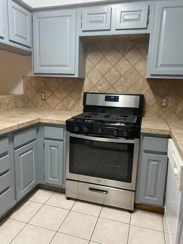 a kitchen with granite countertop white cabinets and white appliances