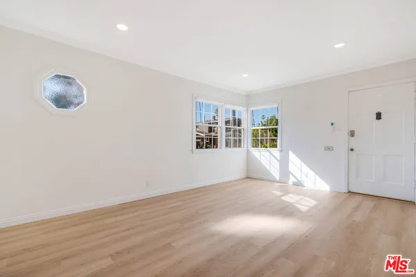 a view of empty room with wooden floor