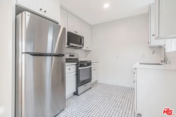 a kitchen with a refrigerator a stove top oven a sink and dishwasher
