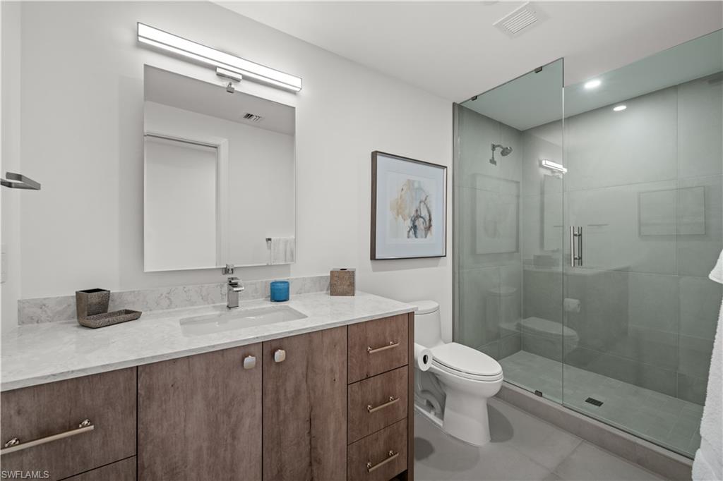 13925 Old Coast Road, Unit 1003 Naples, FL 34110 - Photo 18 of 33 Bathroom with vanity and a shower stall