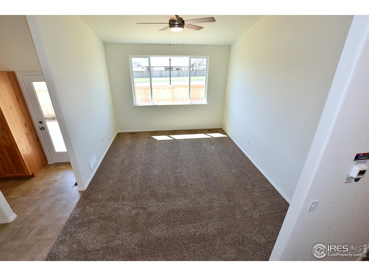 2304 Sublime Drive Windsor, CO 80550 - Photo 27 of 39 a view of an empty room with wooden floor and a window