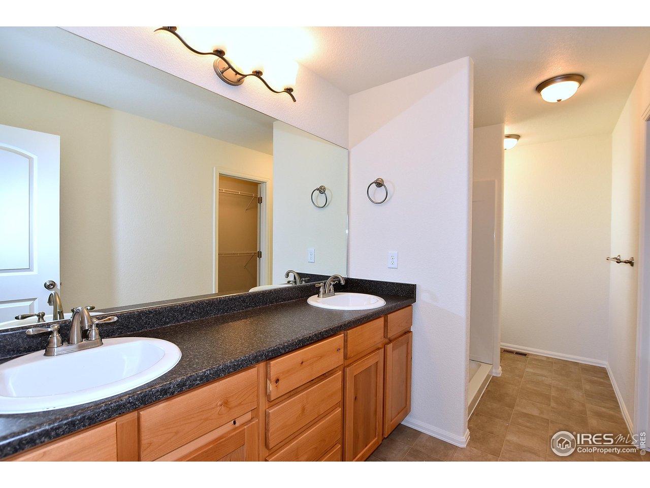 2304 Sublime Drive Windsor, CO 80550 - Photo 29 of 39 a bathroom with a granite countertop sink and a mirror
