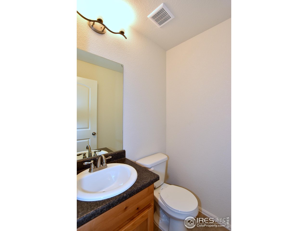 2304 Sublime Drive Windsor, CO 80550 - Photo 31 of 39 a bathroom with a toilet a sink and mirror