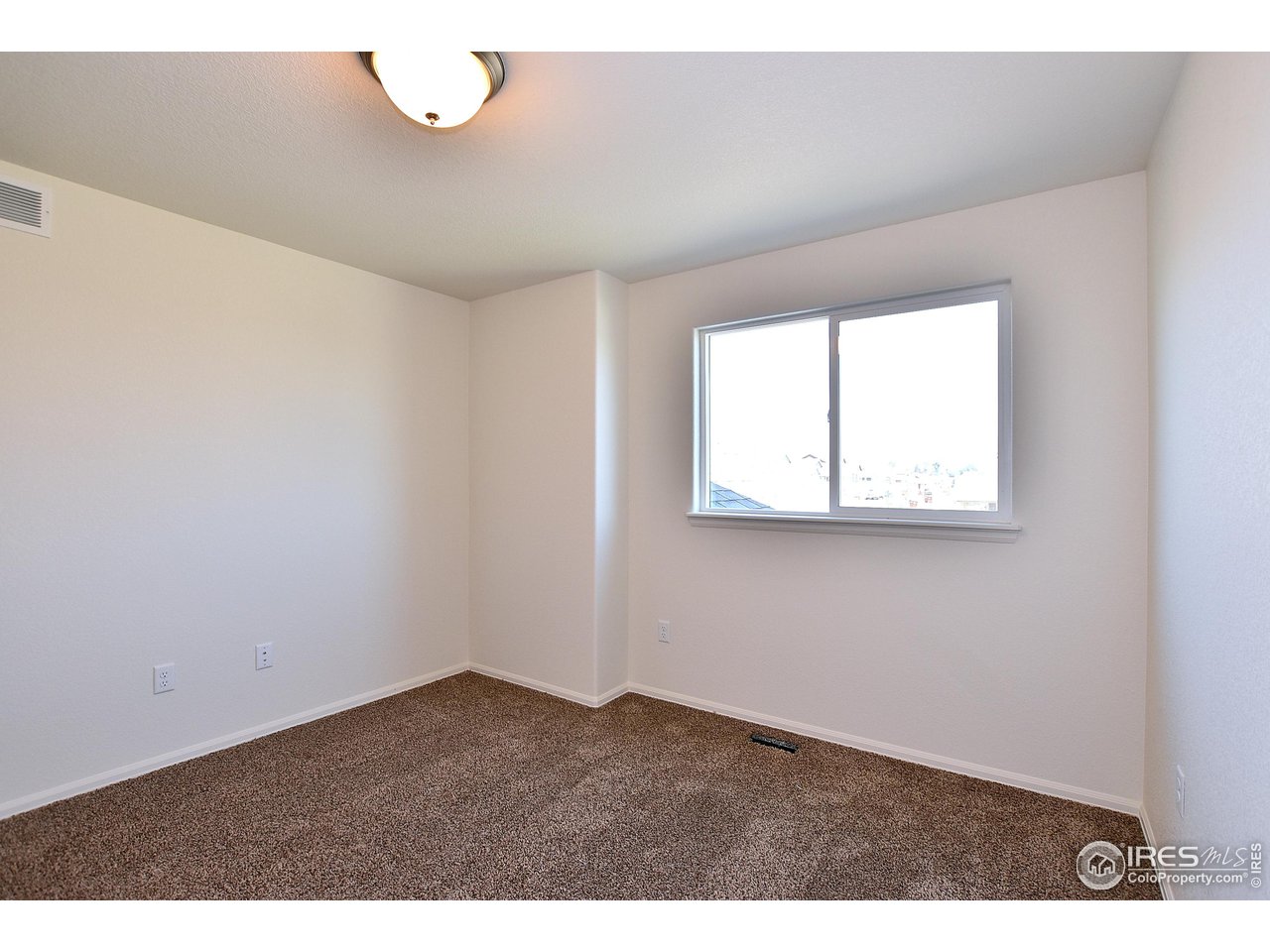 2304 Sublime Drive Windsor, CO 80550 - Photo 32 of 39 an empty room with wooden floor and windows