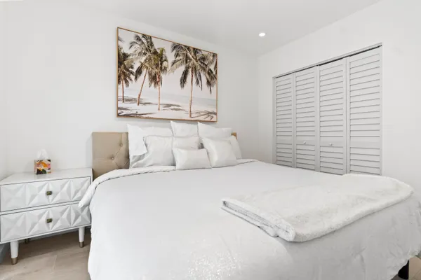 a bedroom with a bed and painting on the wall
