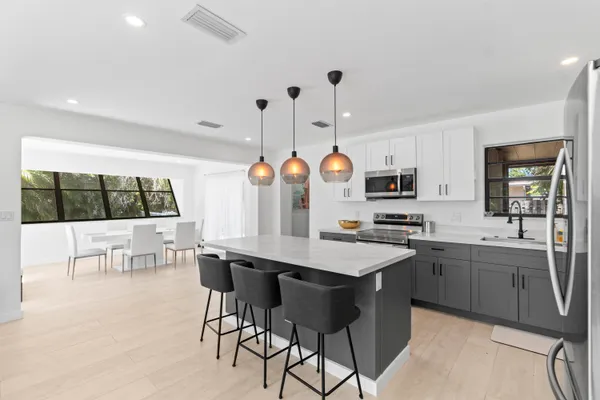 a kitchen with stainless steel appliances kitchen island granite countertop a sink and cabinets