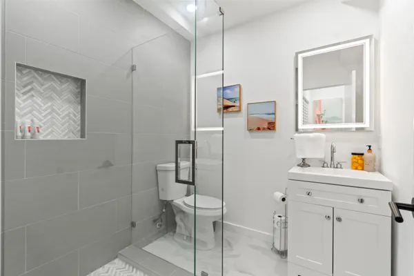 a bathroom with a sink mirror and a shower