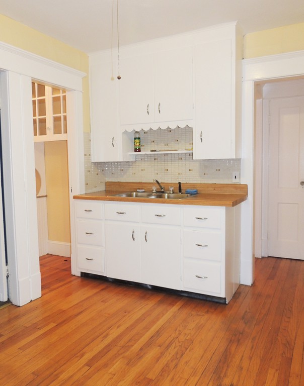 60-62 Edendale Street Springfield, MA 01104 - Photo 3 of 10 a room with kitchen island stainless steel appliances a stove and a window