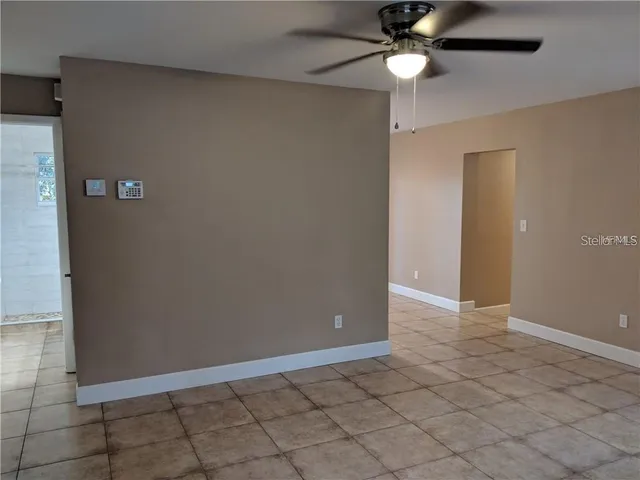 an empty room with closet and a chandelier fan