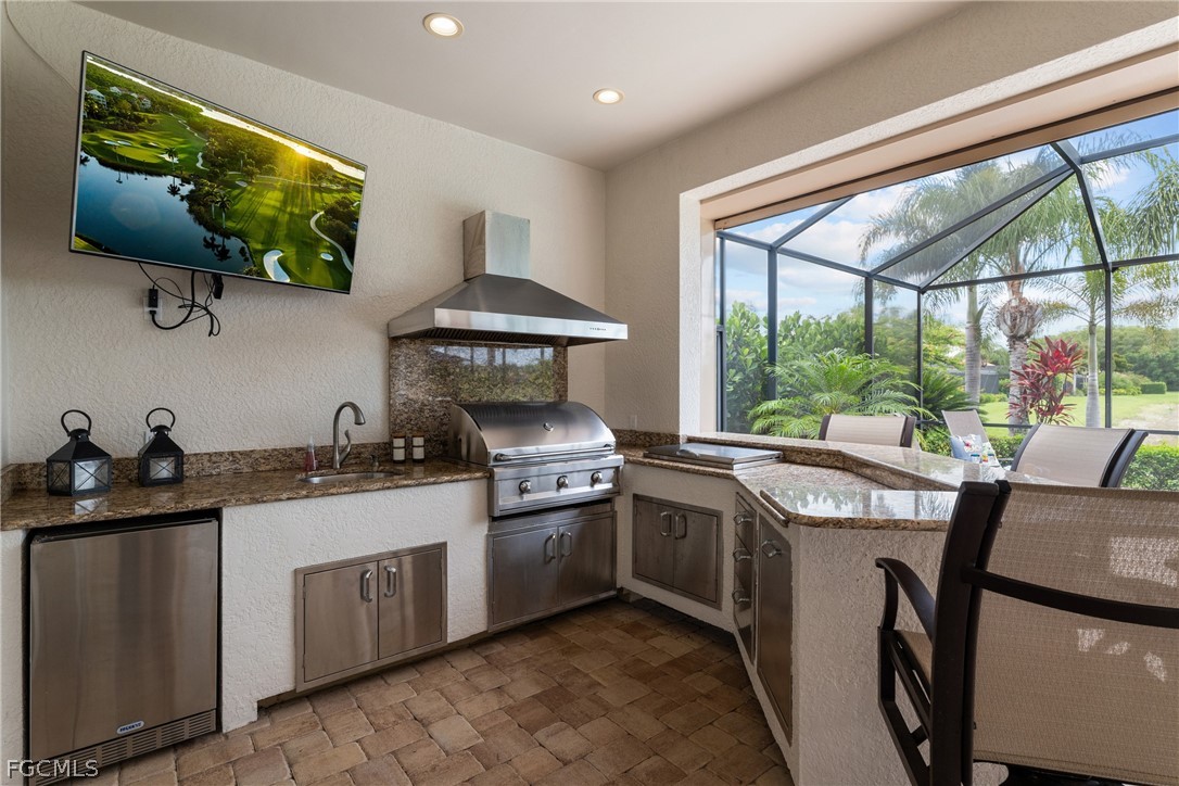 9383 Slate Court Naples, FL 34120 - Photo 20 of 28 a kitchen with stainless steel appliances granite countertop a stove a sink and a microwave