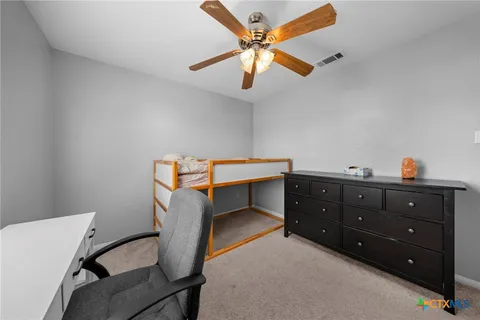 a room with a table and a ceiling fan