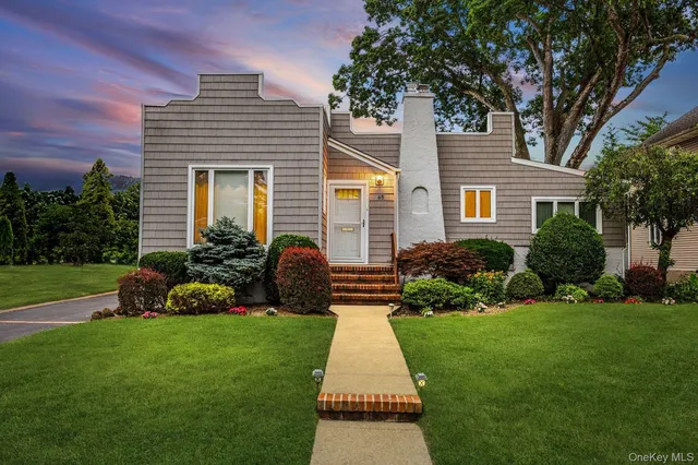 a front view of a house with a garden and plants