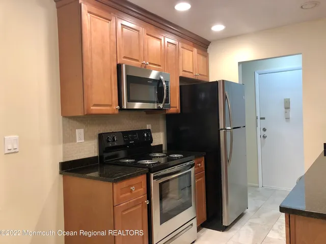 a kitchen with stainless steel appliances granite countertop a refrigerator stove and microwave