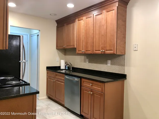 a kitchen with granite countertop a stove sink and cabinets