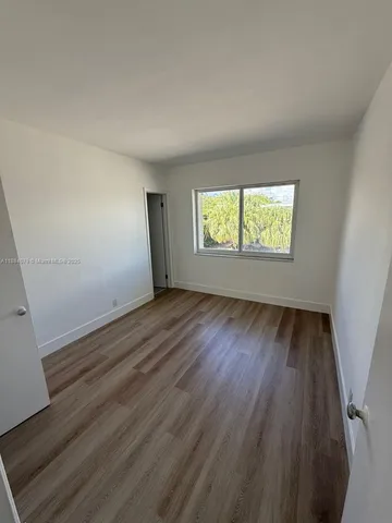 an empty room with wooden floor and closet