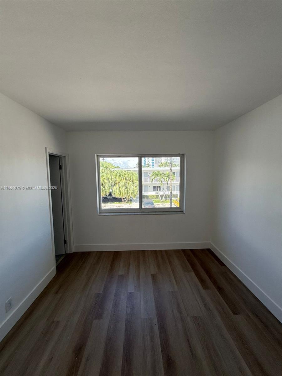 10074 East Bay Harbor Drive, Unit 74C Bay Harbor Islands, FL 33154 - Photo 14 of 28 an empty room with wooden floor and windows