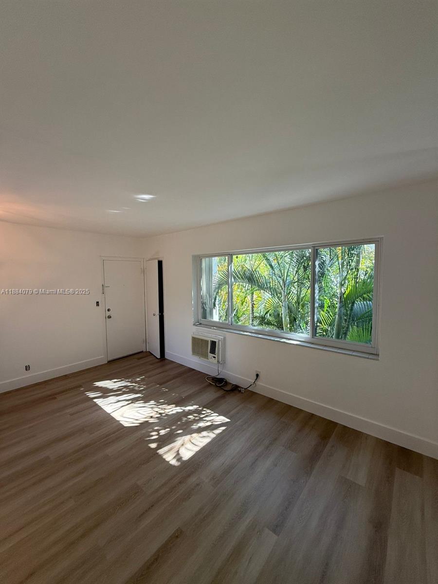 10074 East Bay Harbor Drive, Unit 74C Bay Harbor Islands, FL 33154 - Photo 4 of 28 a view of an empty room with wooden floor and a window