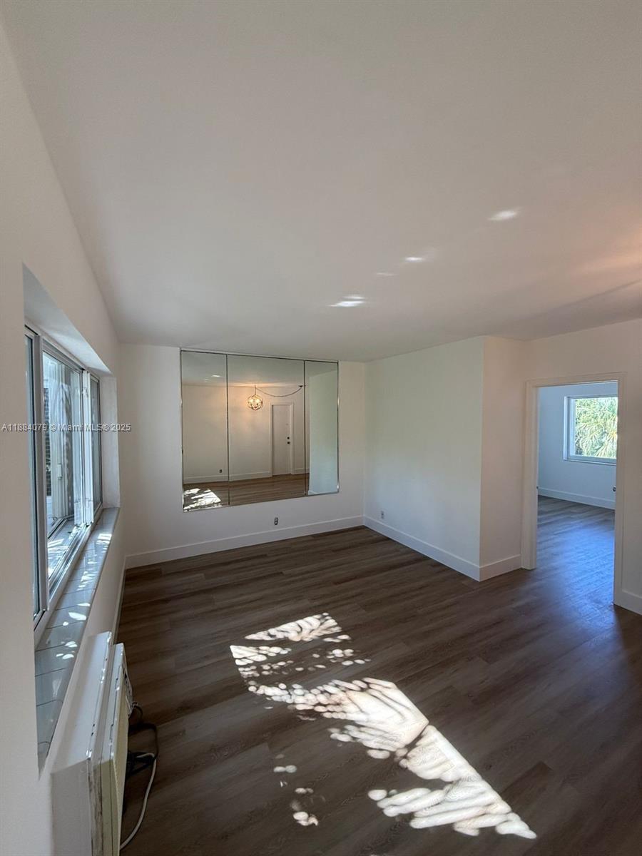 10074 East Bay Harbor Drive, Unit 74C Bay Harbor Islands, FL 33154 - Photo 7 of 28 a view of an empty room with wooden floor and a window