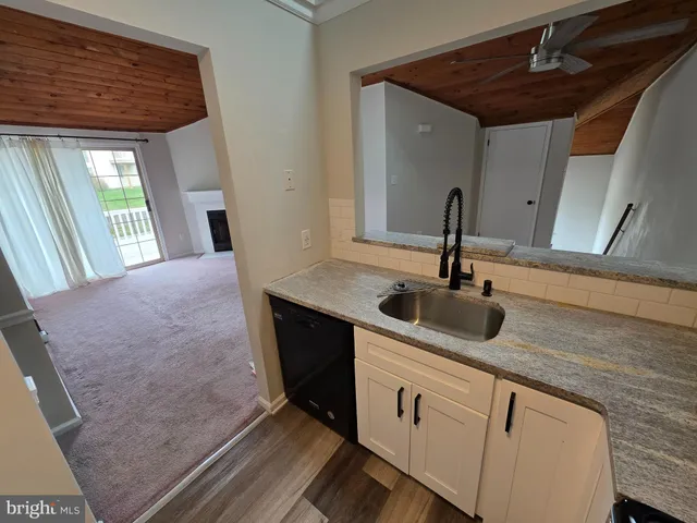 a view of a hallway with a door and wooden floor