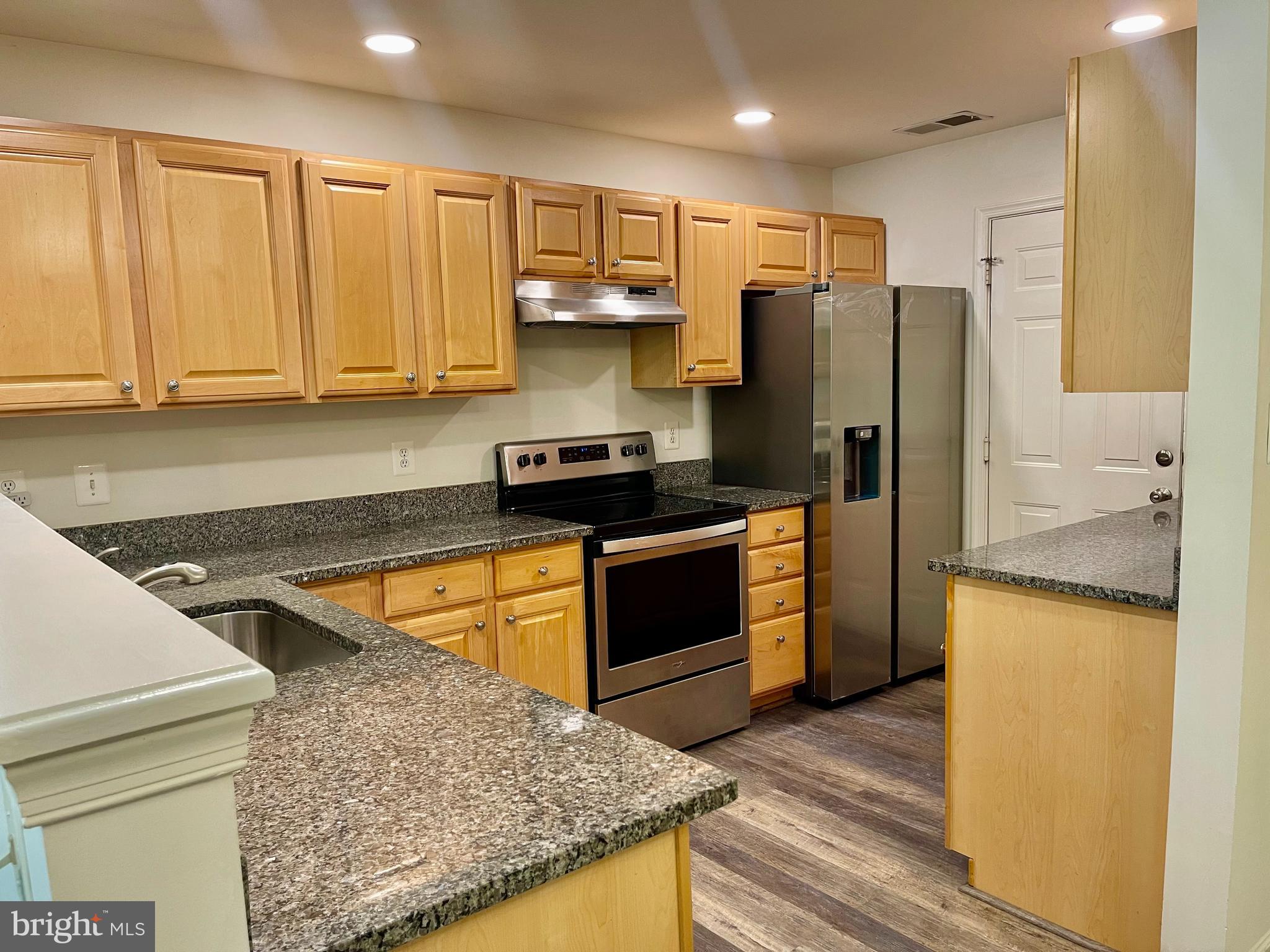 1883 Crescent Park Drive, Unit 112A Reston, VA 20190 - Photo 8 of 23 a kitchen with stainless steel appliances granite countertop a refrigerator sink and stove