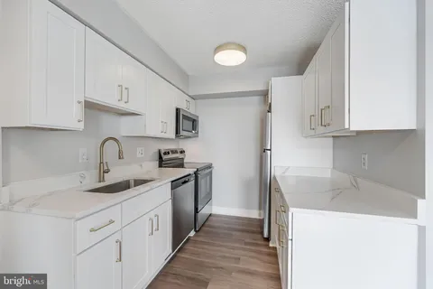 a kitchen with kitchen island granite countertop a sink stainless steel appliances and cabinets