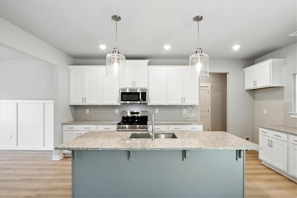 4034 Links Boulevard Jefferson, GA 30549 - Photo 15 of 68 a kitchen with stainless steel appliances granite countertop a sink a stove a refrigerator a center island and cabinets