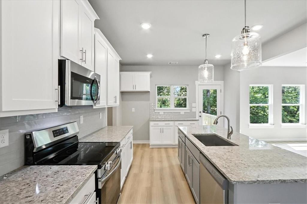 4034 Links Boulevard Jefferson, GA 30549 - Photo 18 of 68 a kitchen with granite countertop a sink a counter top space appliances and cabinets