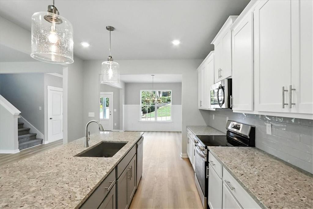 4034 Links Boulevard Jefferson, GA 30549 - Photo 19 of 68 a kitchen with stainless steel appliances granite countertop a sink stove and refrigerator