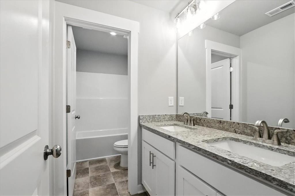 4034 Links Boulevard Jefferson, GA 30549 - Photo 44 of 68 a bathroom with a granite countertop sink and a mirror
