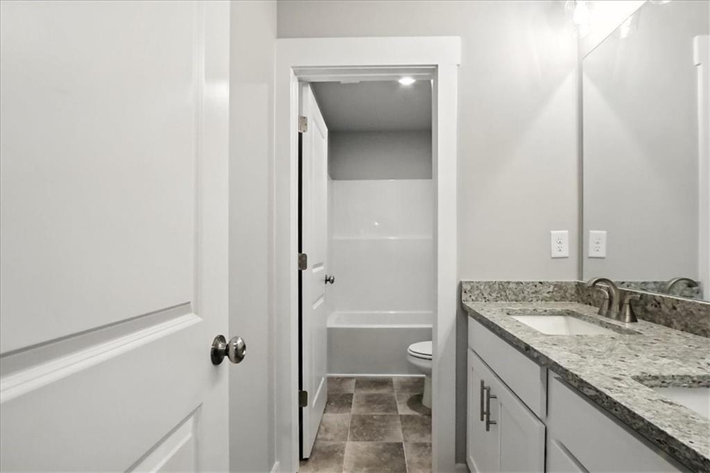4034 Links Boulevard Jefferson, GA 30549 - Photo 45 of 68 a bathroom with a granite countertop sink and a mirror