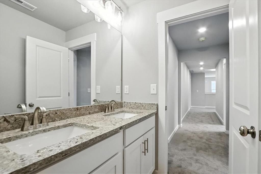 4034 Links Boulevard Jefferson, GA 30549 - Photo 47 of 68 a bathroom with a granite countertop sink and a mirror
