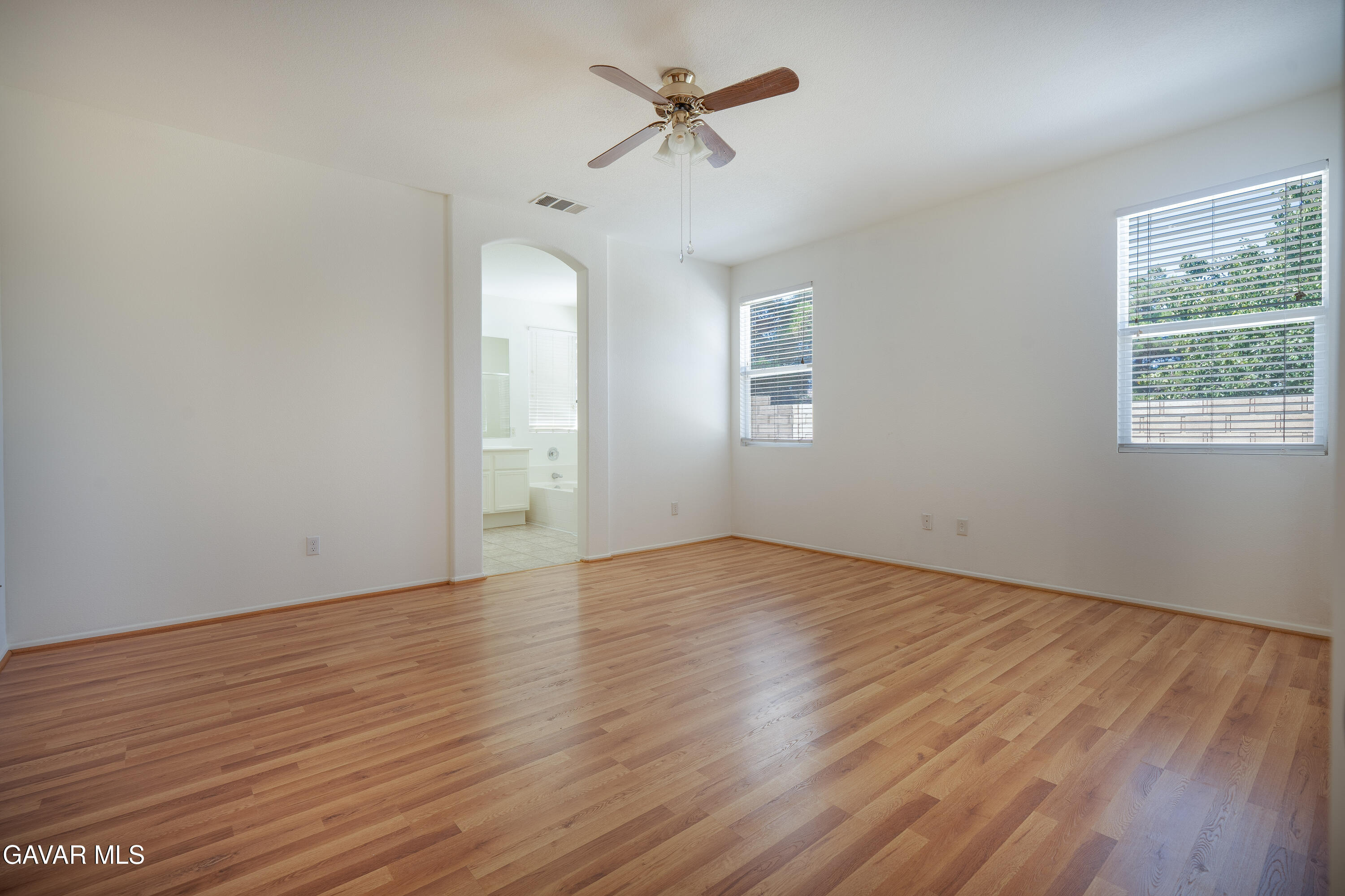 40263 Preston Road Palmdale, CA 93551 - Photo 15 of 24 an empty room with wooden floor chandelier fan and windows