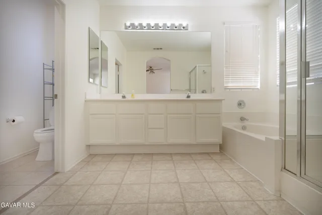 a spacious bathroom with a mirror sink and a bathtub