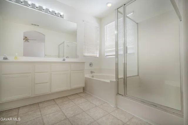 a spacious bathroom with a shower a mirror and a bathtub