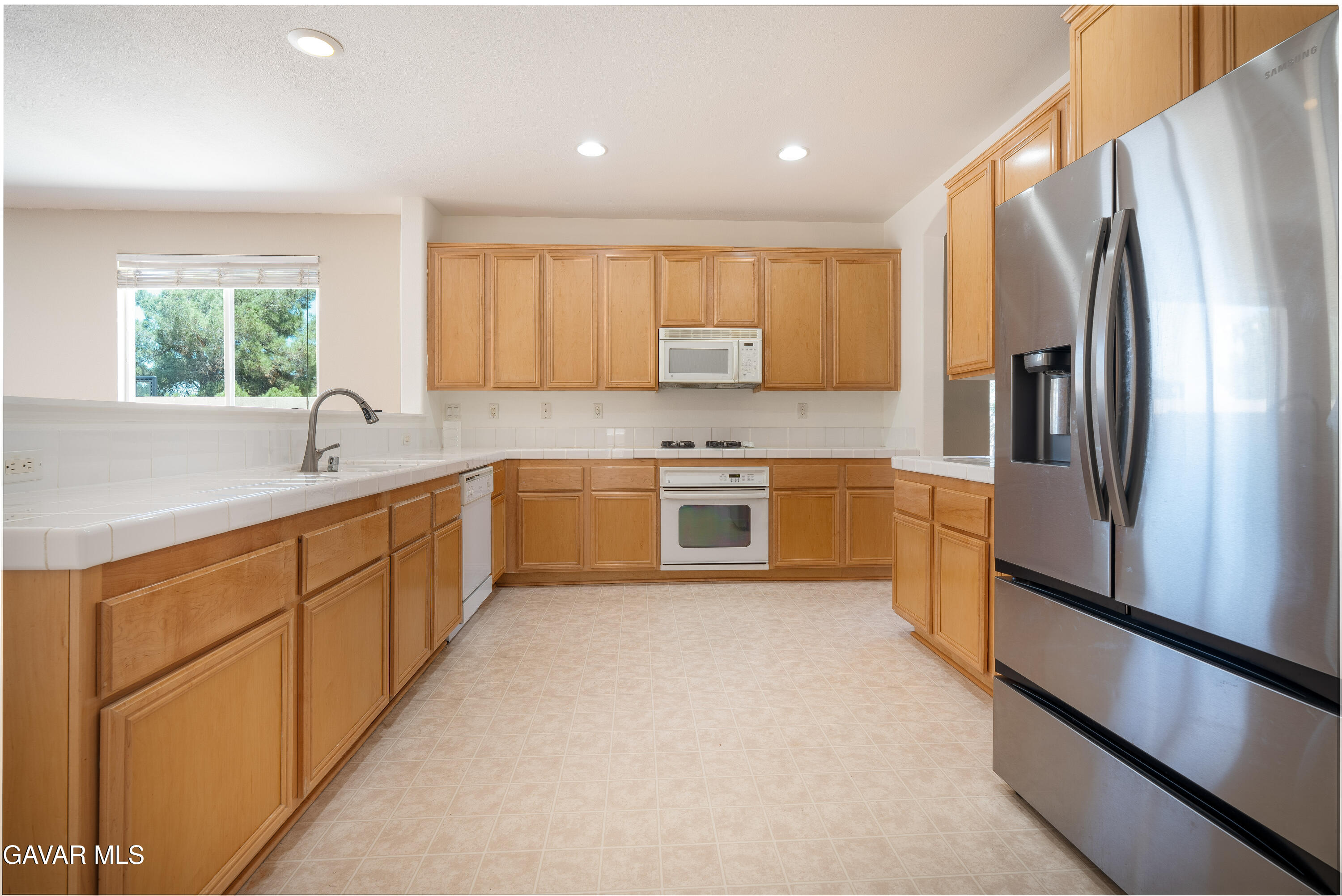 40263 Preston Road Palmdale, CA 93551 - Photo 23 of 24 a kitchen with white cabinets and stainless steel appliances
