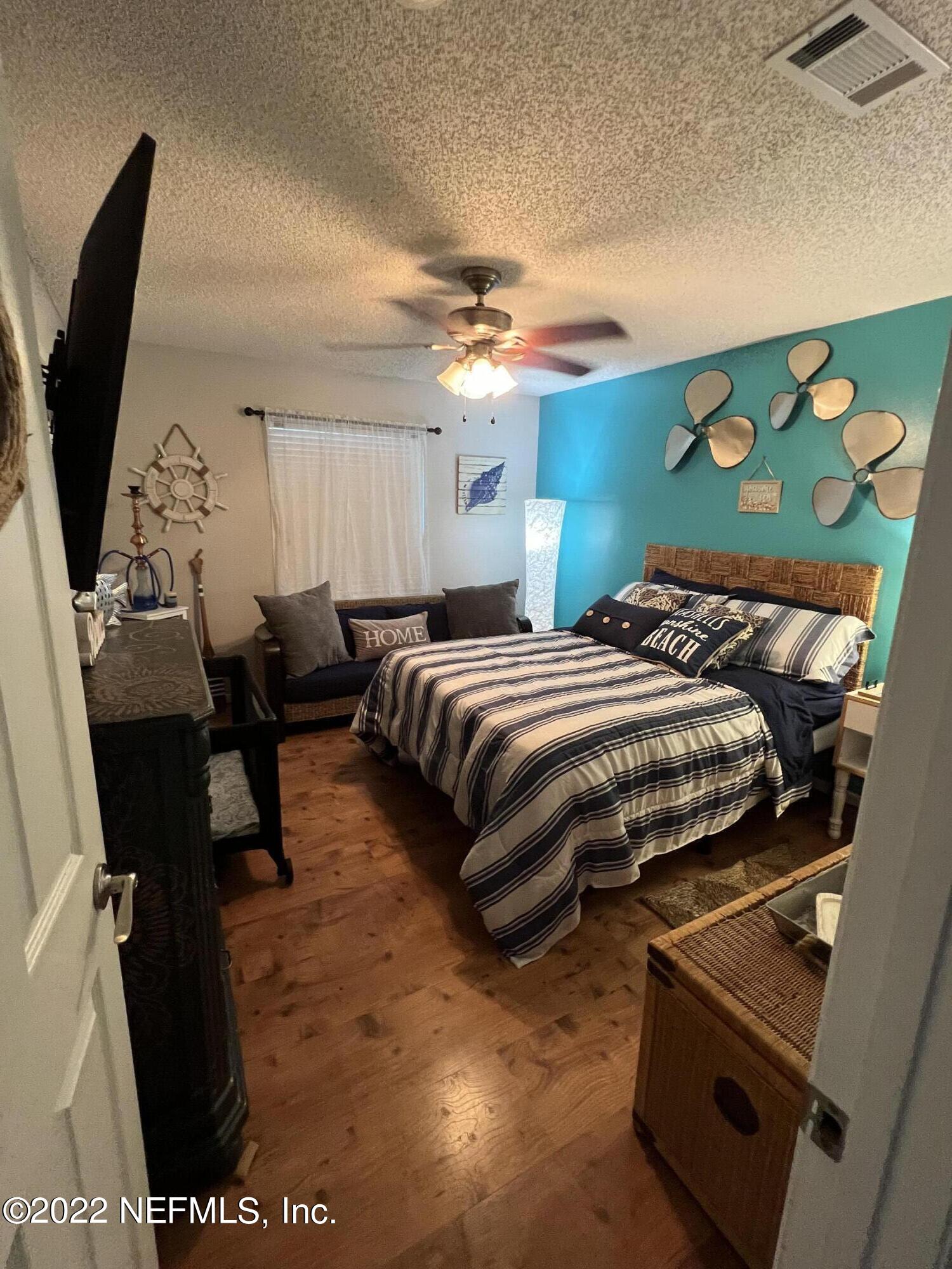 6044 West Shores Road Fleming Island, FL 32003 - Photo 13 of 18 a bedroom with a bed and flat screen tv