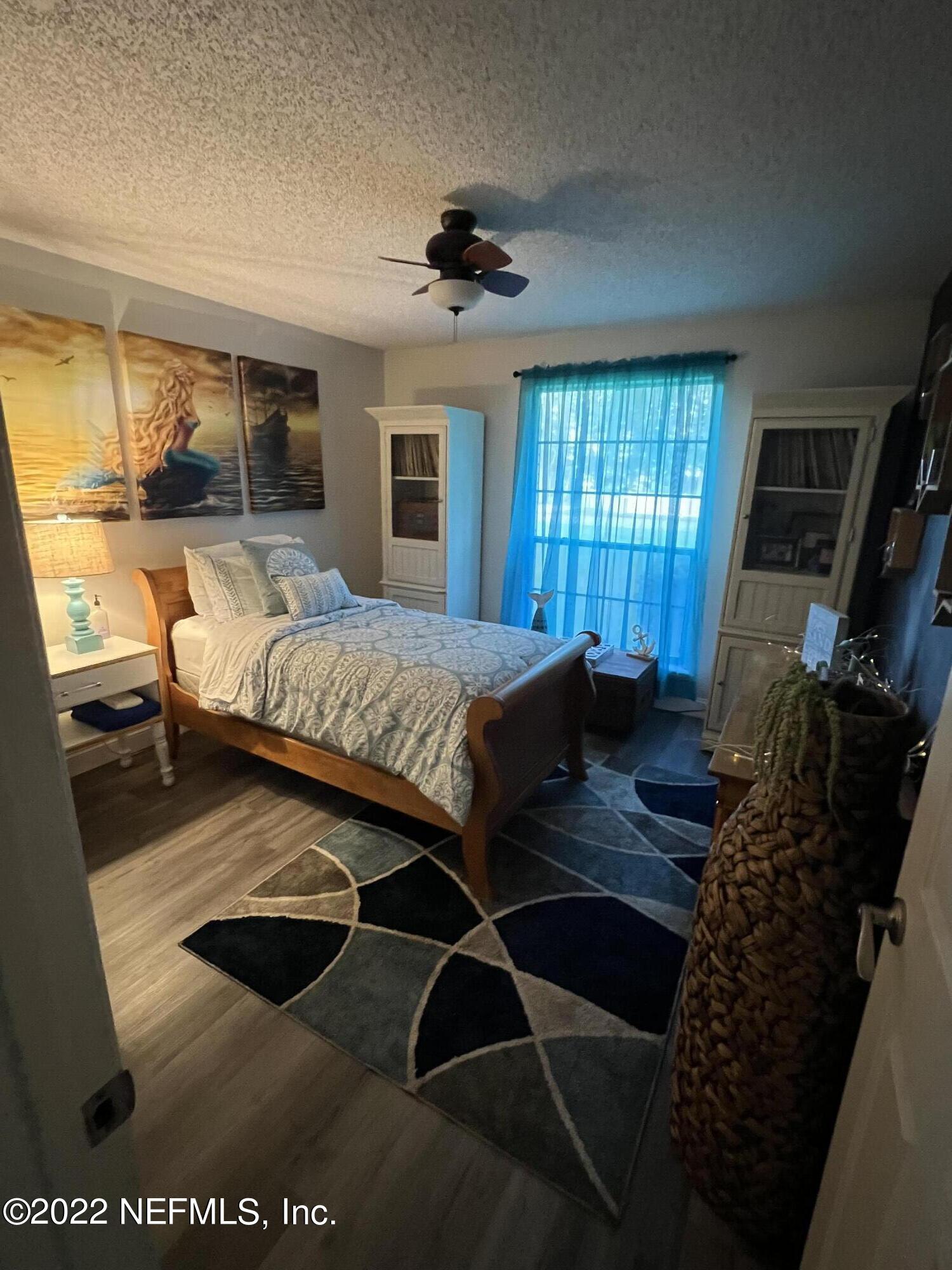 6044 West Shores Road Fleming Island, FL 32003 - Photo 14 of 18 a bedroom with a large bed and a flat tv screen on dresser