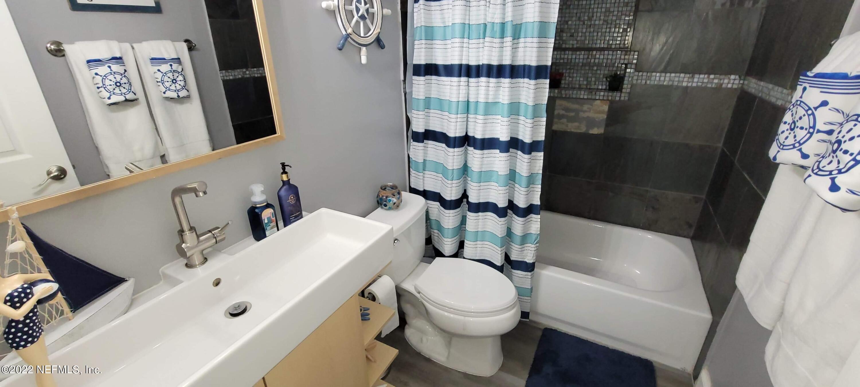 6044 West Shores Road Fleming Island, FL 32003 - Photo 15 of 18 a white toilet sitting next to a bathroom sink and tub