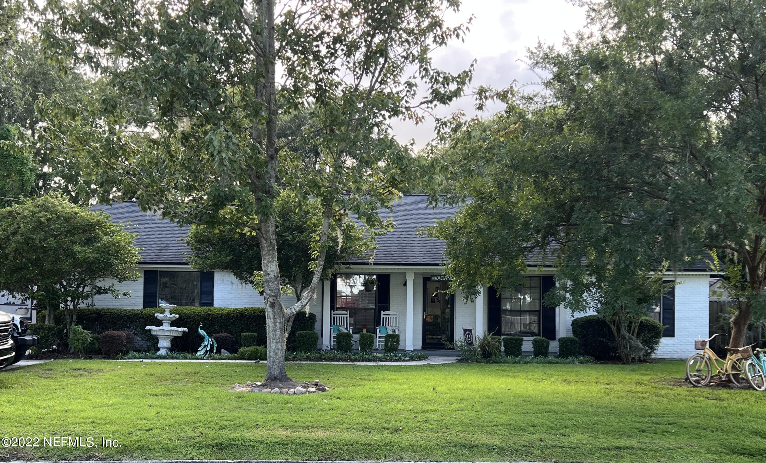 6044 West Shores Road Fleming Island, FL 32003 - Photo 4 of 18 a front view of a house with a yard and trees