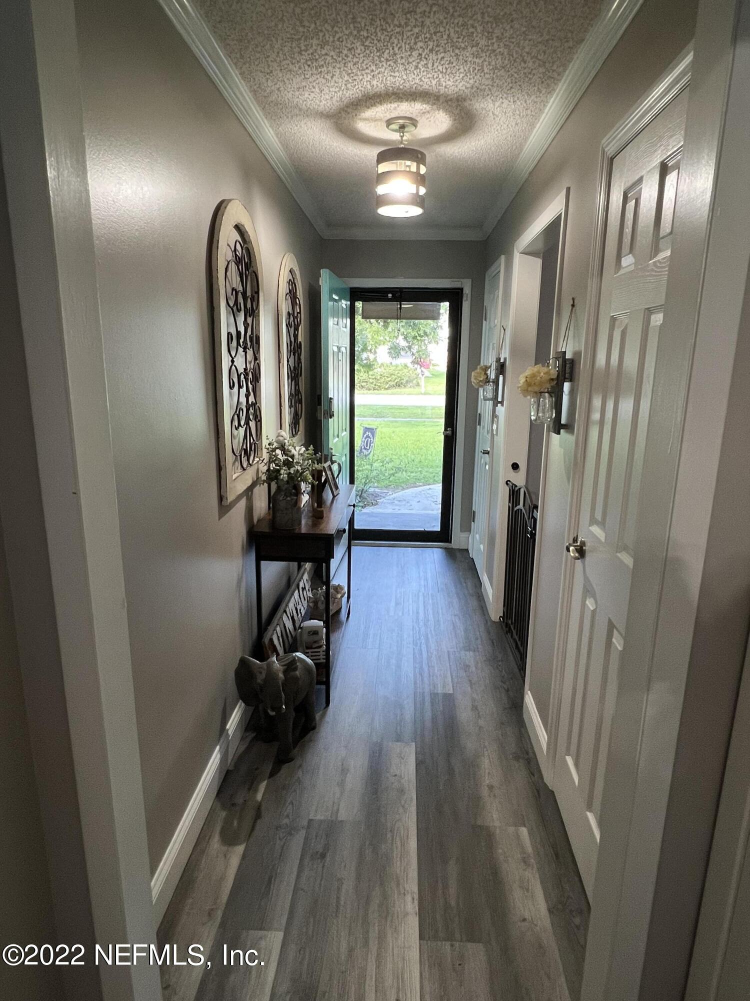 6044 West Shores Road Fleming Island, FL 32003 - Photo 5 of 18 a view of a hallway with wooden floor